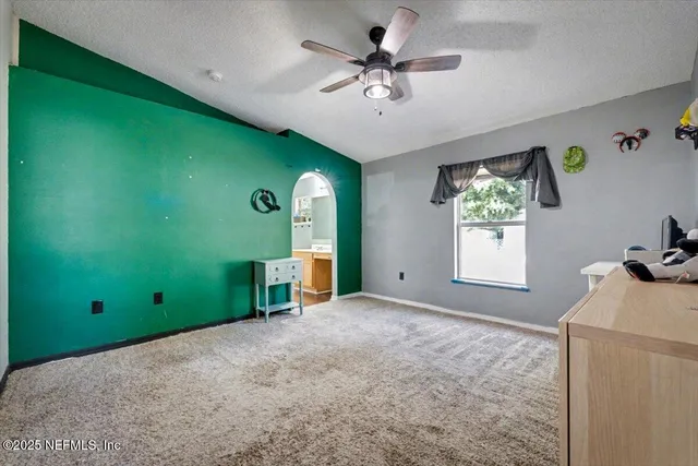 a view of a room with window ceiling fan and a kitchen view