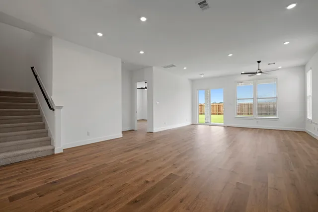a view of empty room with wooden floor and fireplace