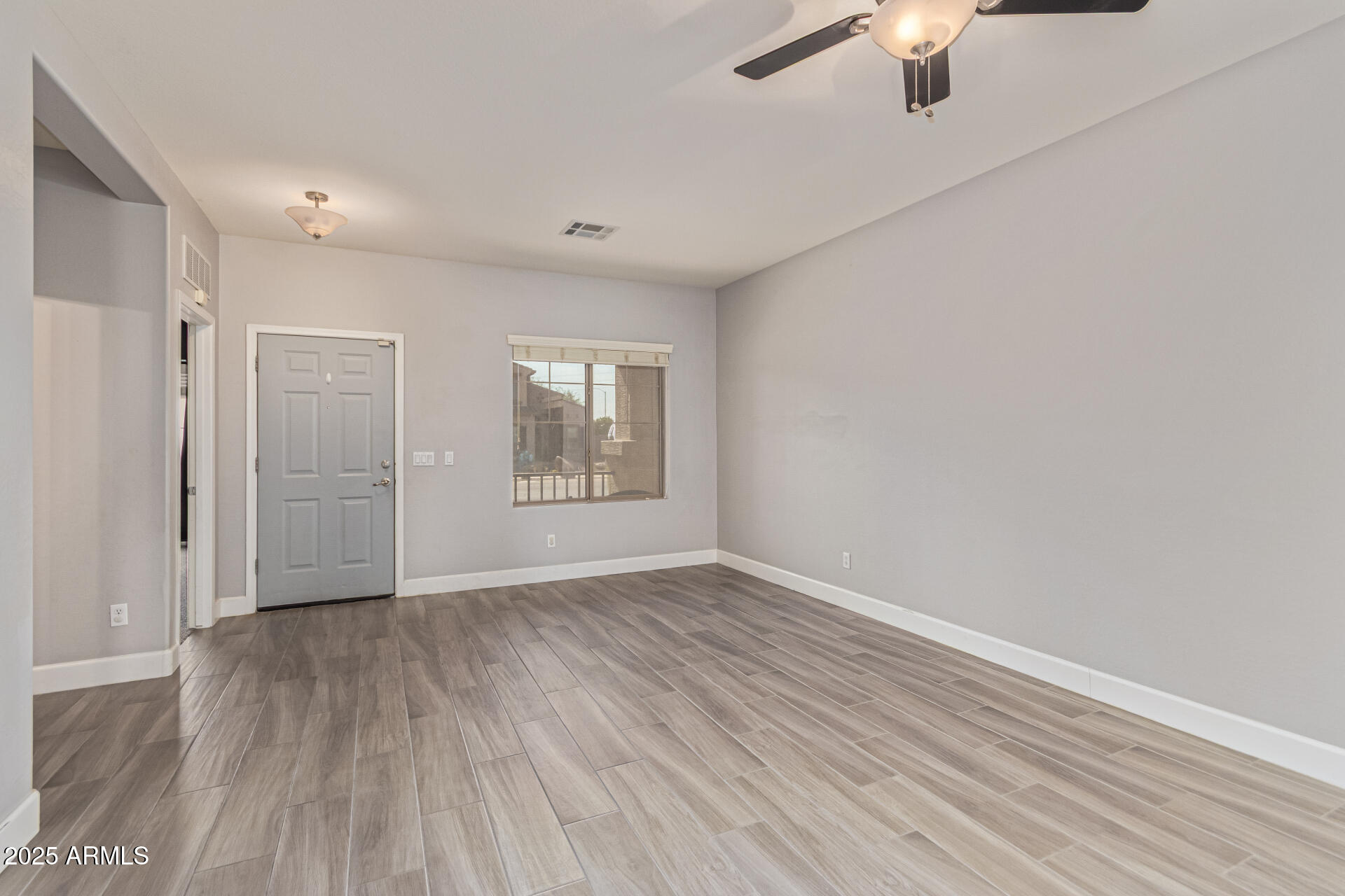17868 West Charter Oak Road Surprise, AZ 85388 - Photo 9 of 67 wooden floor in an empty room with a window