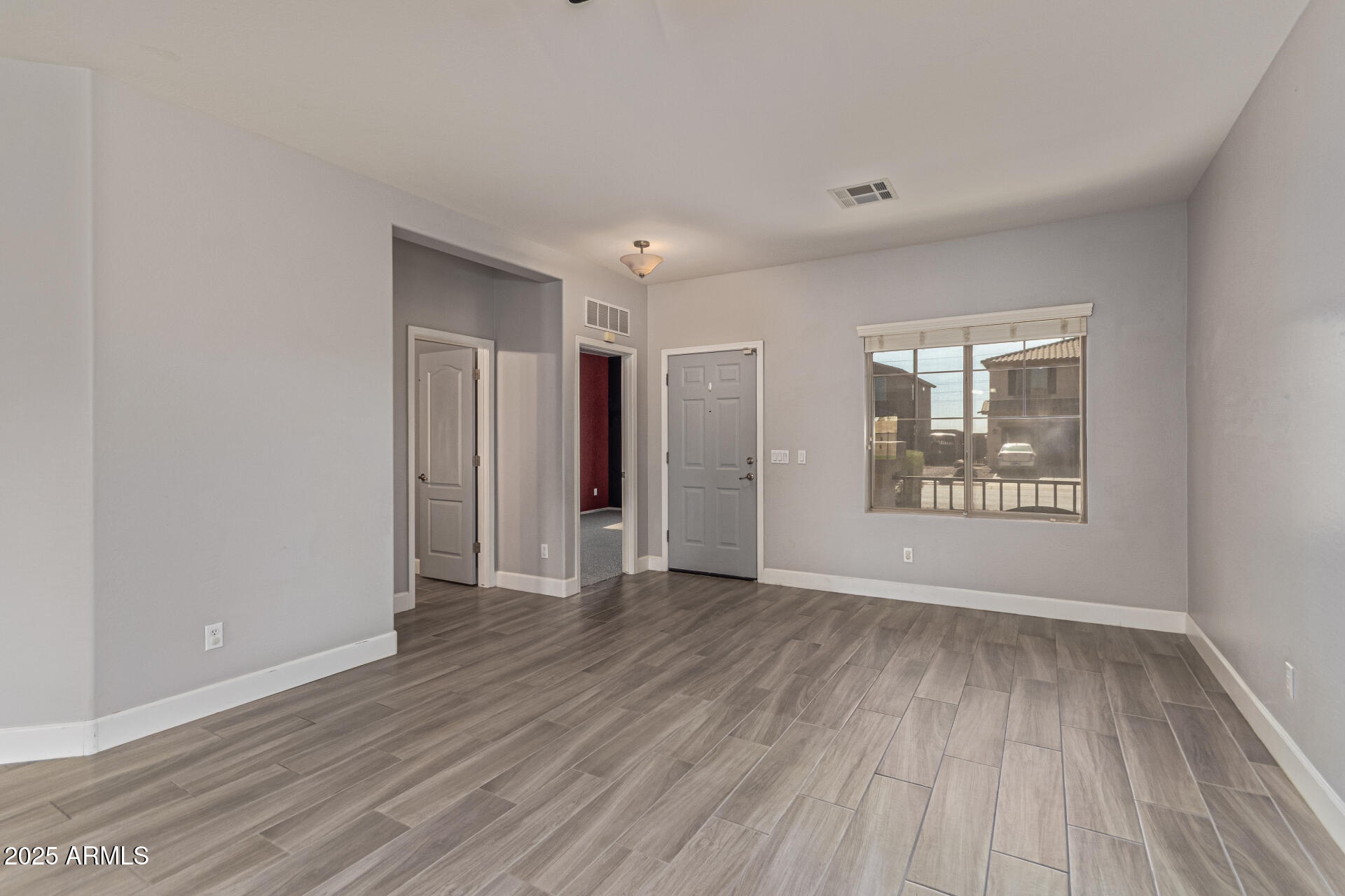 17868 West Charter Oak Road Surprise, AZ 85388 - Photo 10 of 67 a view of an empty room with wooden floor and a window