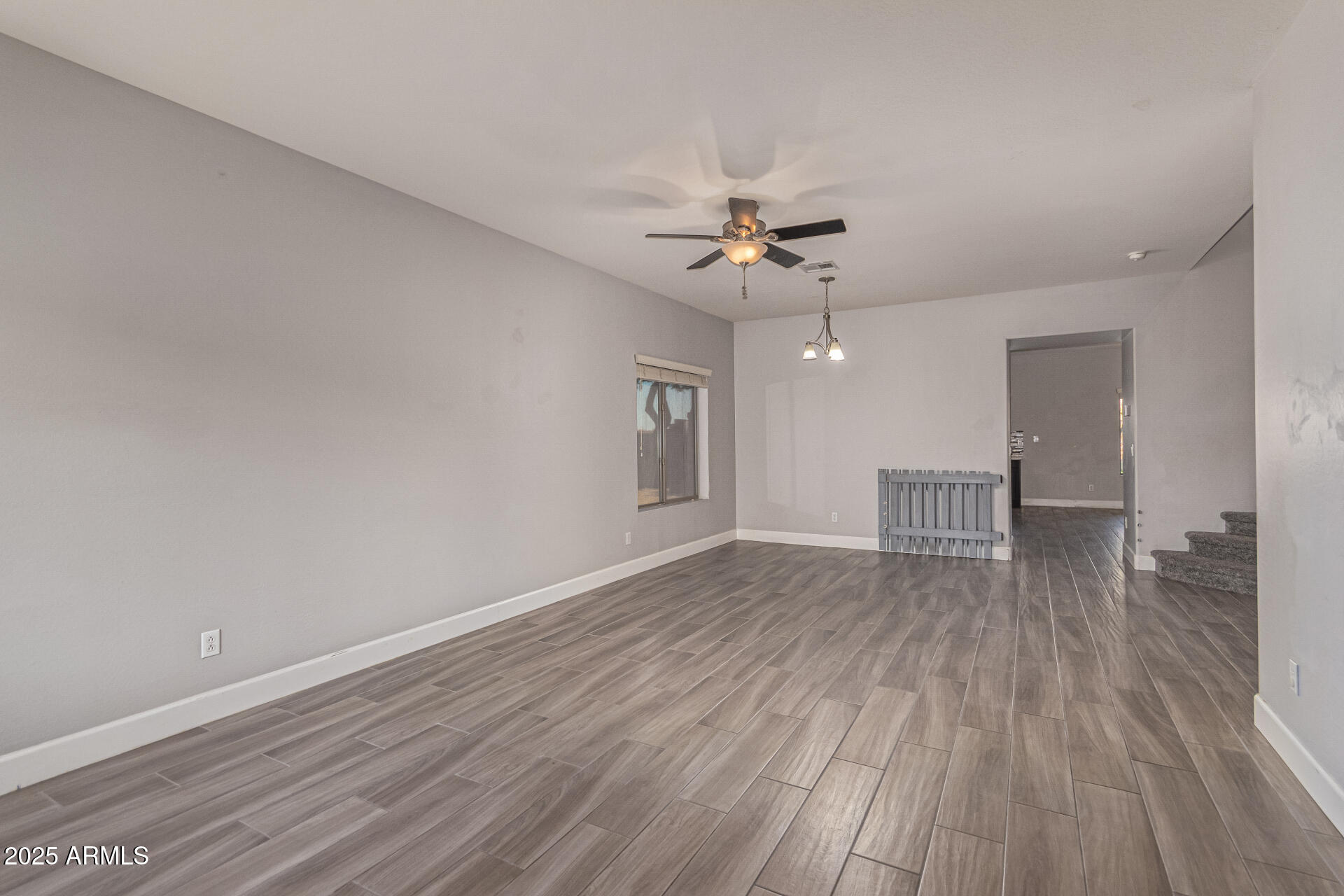 17868 West Charter Oak Road Surprise, AZ 85388 - Photo 12 of 67 a view of empty room with wooden floor and ceiling fan