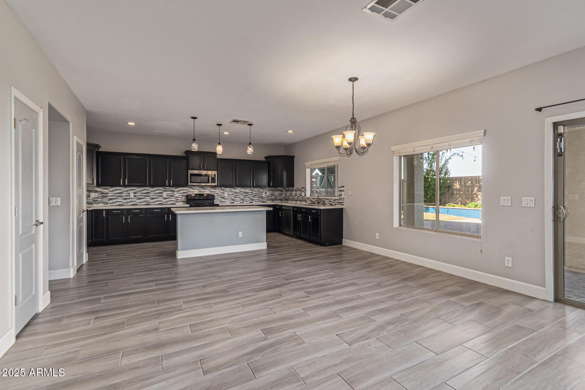 17868 West Charter Oak Road Surprise, AZ 85388 - Photo 15 of 67 a view of a kitchen with kitchen island a chandelier and wooden floor