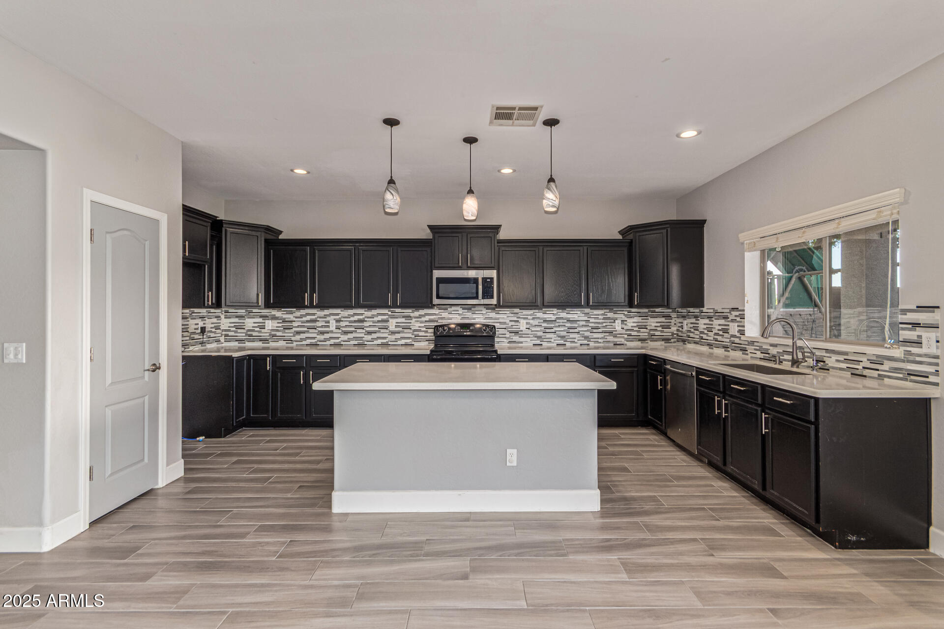 17868 West Charter Oak Road Surprise, AZ 85388 - Photo 20 of 67 a large kitchen with stainless steel appliances a large counter top a stove and a sink