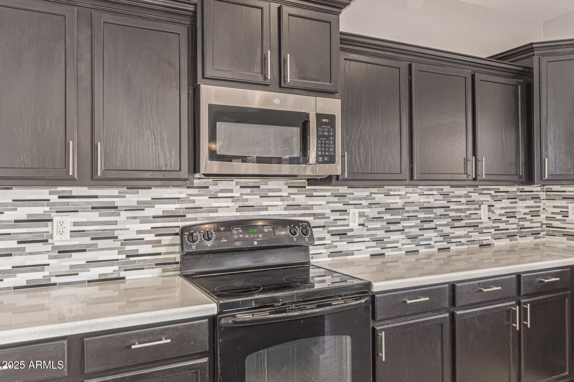17868 West Charter Oak Road Surprise, AZ 85388 - Photo 23 of 67 a kitchen with granite countertop cabinets stove and microwave