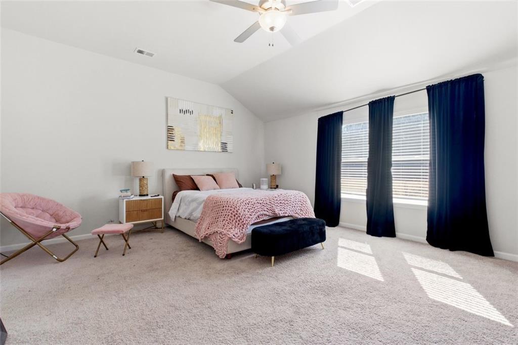 4006 Riverchess Drive Southwest Atlanta, GA 30331 - Photo 22 of 28 a spacious bedroom with a bed and a chandelier