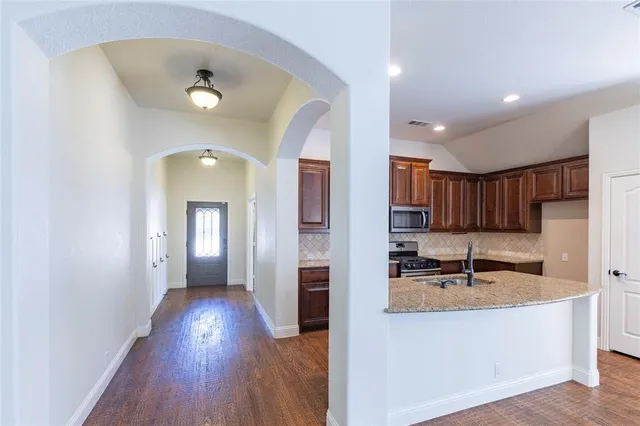 a kitchen with granite countertop a refrigerator and a sink