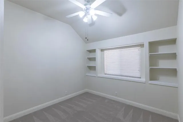 an empty room with a window and a fan