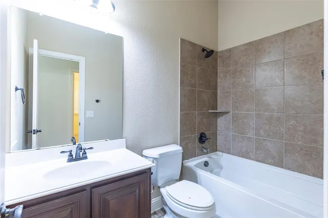 a bathroom with a sink a toilet a mirror a bathtub and shower