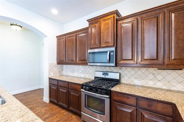 a kitchen with granite countertop cabinets stainless steel appliances and wooden cabinets