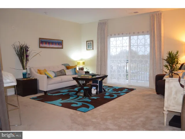 a living room with furniture a table and a large window