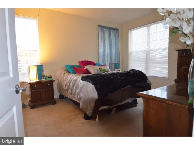 a bedroom with a bed window and a flat tv screen next to a window
