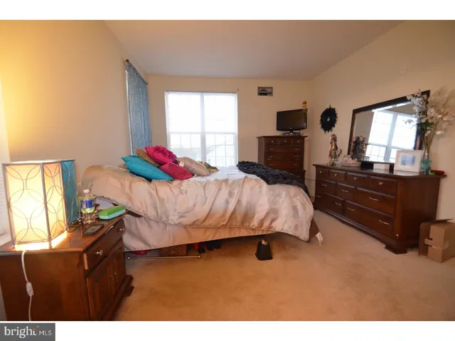 a bedroom with a bed dresser and a flat tv screen