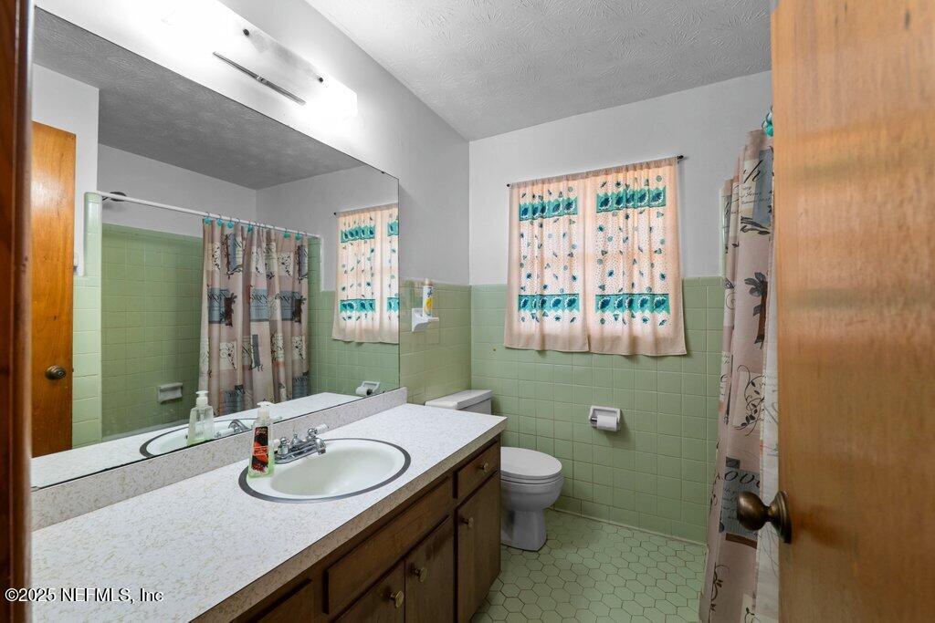 1308 Rigdon Road Jacksonville, FL 32220 - Photo 17 of 32 a bathroom with a granite countertop sink mirror and toilet