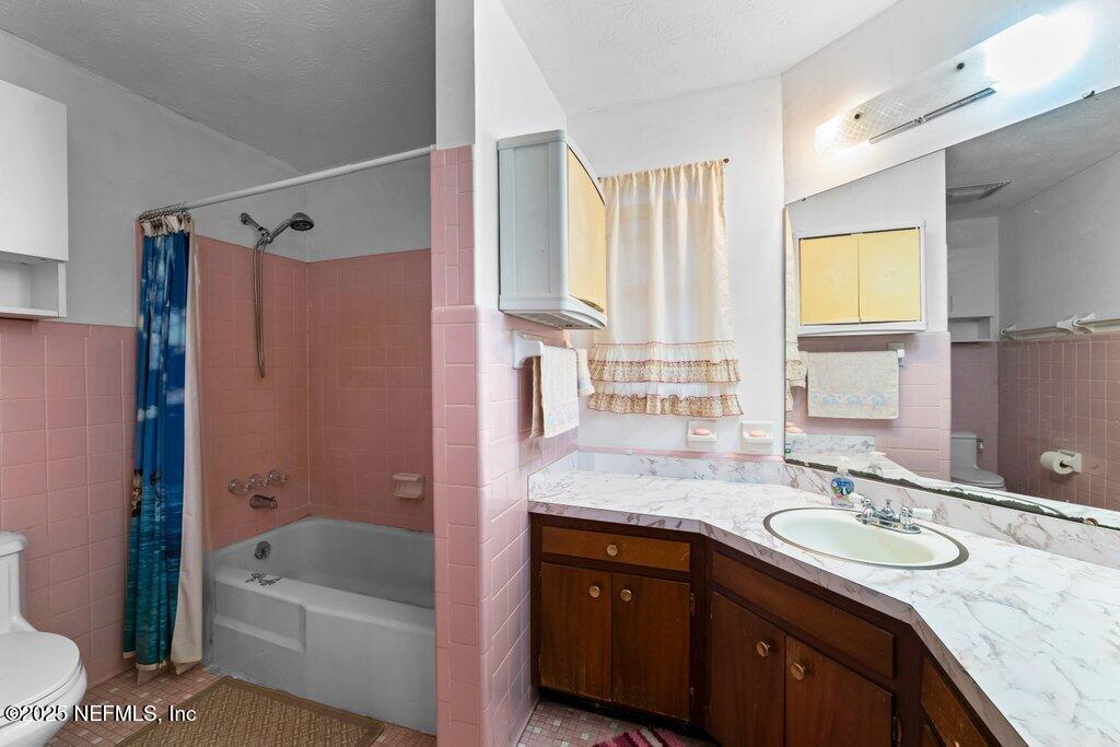 1308 Rigdon Road Jacksonville, FL 32220 - Photo 20 of 32 a bathroom with a granite countertop sink a mirror a bathtub and shower