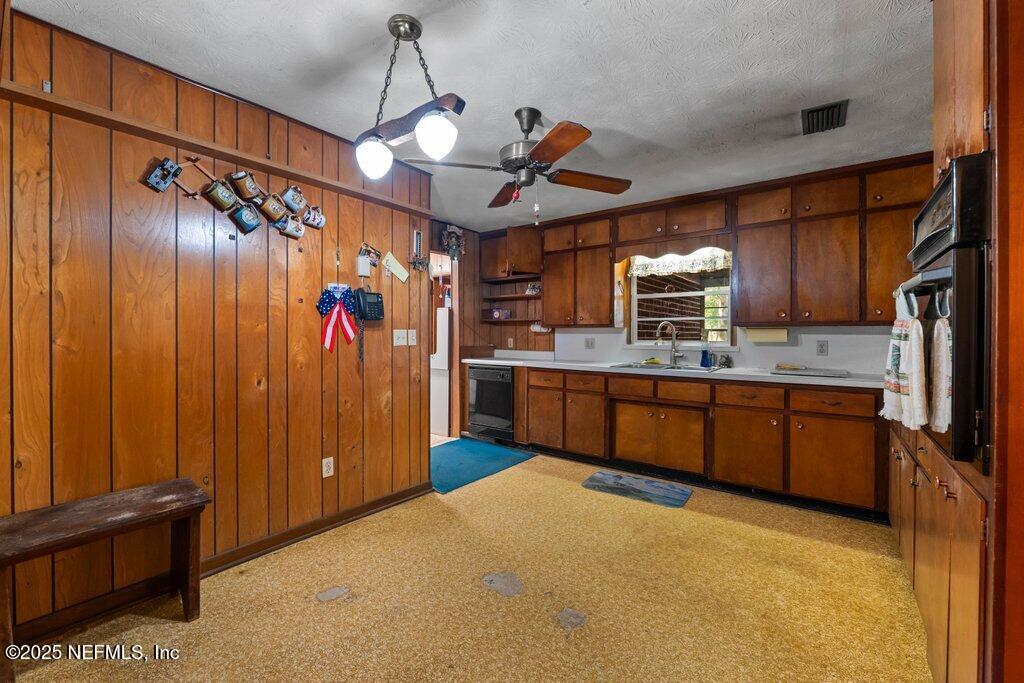 1308 Rigdon Road Jacksonville, FL 32220 - Photo 10 of 32 a kitchen with stainless steel appliances granite countertop wooden cabinets a sink and dishwasher
