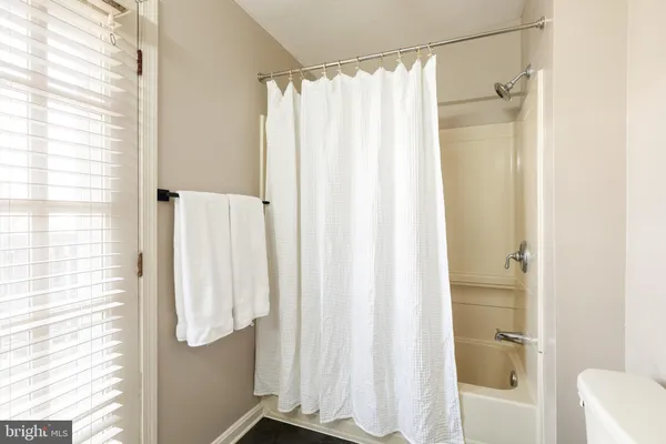 a bathroom with a shower curtain and a window