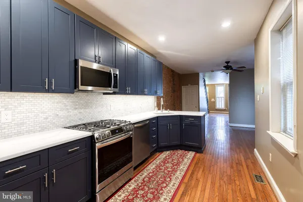 a kitchen with wooden floors wooden cabinets and stainless steel appliances