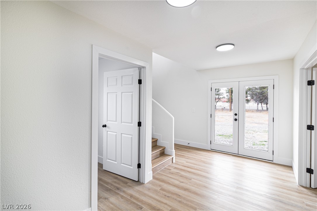 1891 Brian Road Pahrump, NV 89048 - Photo 21 of 50 Foyer featuring stairway, baseboards, light wood-style flooring, and french doors
