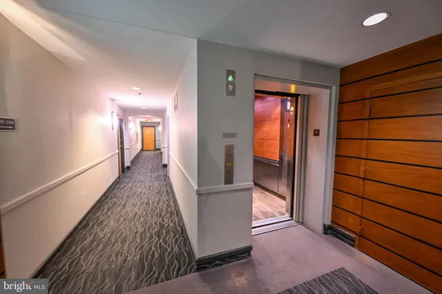 a view of a hallway with wooden floor and closet