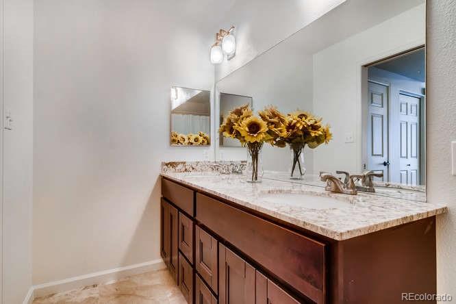 8312 Pebble Creek Way, Unit 104 Highlands Ranch, CO 80126 - Photo 6 of 12 a bathroom with a granite countertop sink and a mirror