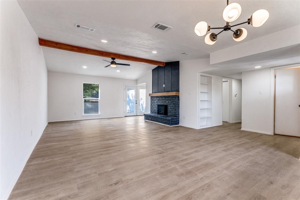 4108 Bristlecone Lane Fort Worth, TX 76137 - Photo 19 of 25 an empty room with a fireplace and ceiling fan