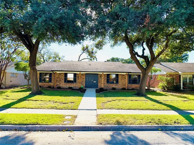 a front view of a house with a yard porch and tree