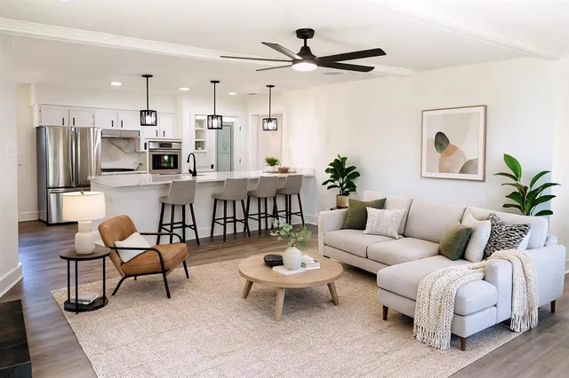 a living room with furniture a fireplace and a large window