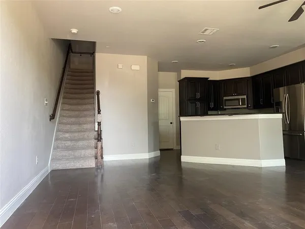 a view of a kitchen with wooden floor and stairs