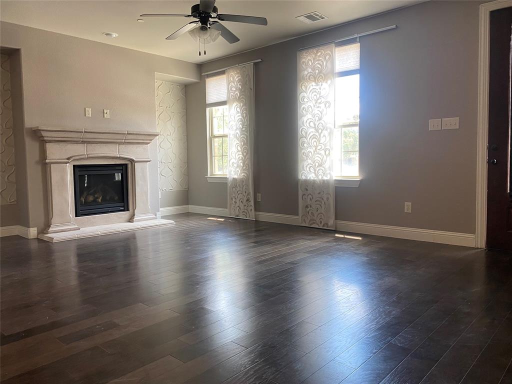 4232 Charles Road Carrollton, TX 75010 - Photo 9 of 21 an empty room with wooden floor fireplace and windows