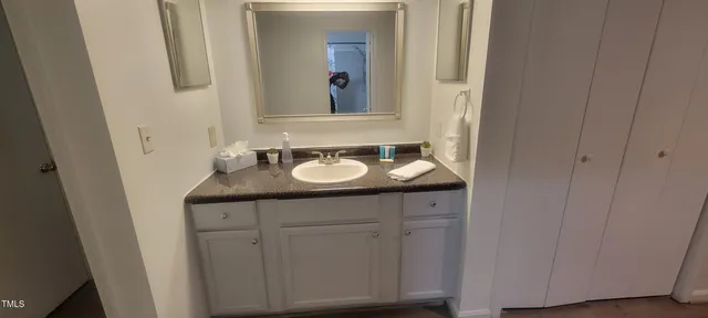 a bathroom with a granite countertop sink and a mirror