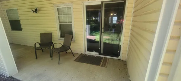 a backyard of a house with table and chairs