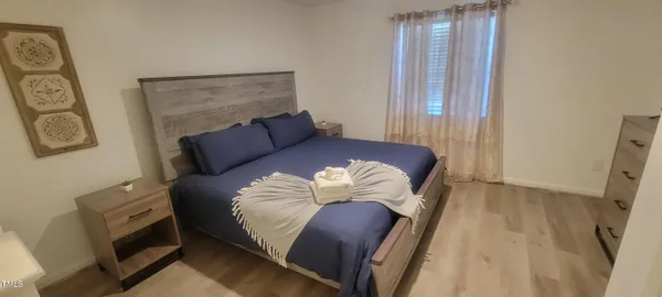 a bedroom with a bed and wooden floor