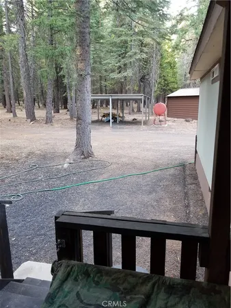 a view of a patio with table and chairs with wooden floor and fence