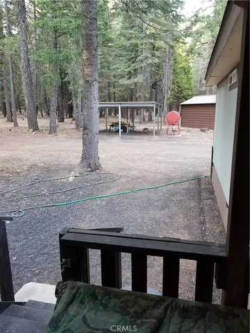 a view of a patio with table and chairs with wooden floor and fence