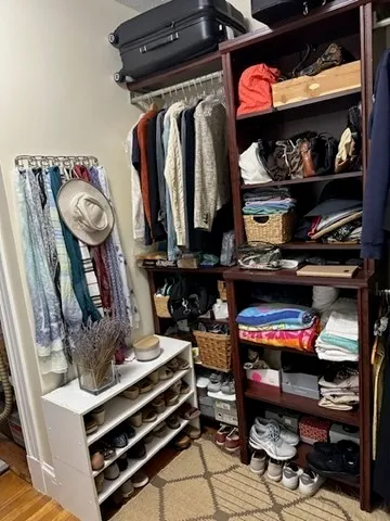 a view of walk in closet with clothes and shoes