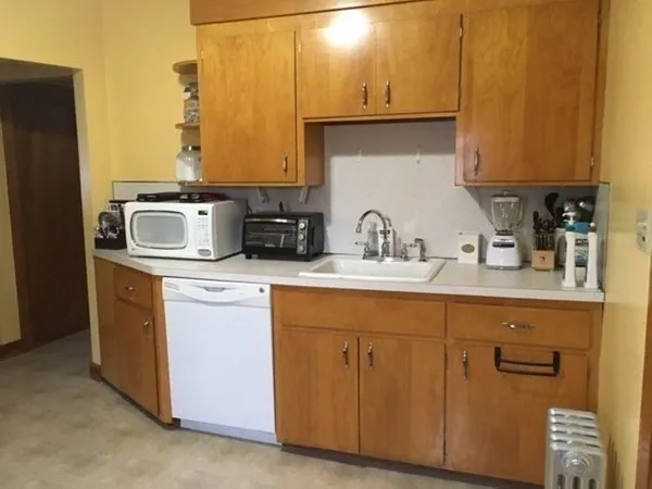 a kitchen with stainless steel appliances granite countertop a sink a stove and a refrigerator with wooden cabinets