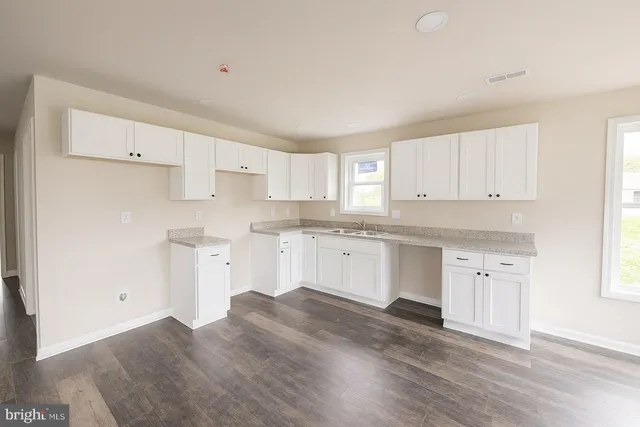 a kitchen with granite countertop white cabinets and white appliances