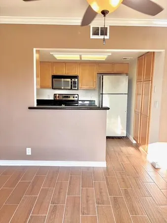 a kitchen with granite countertop a refrigerator and a stove top oven