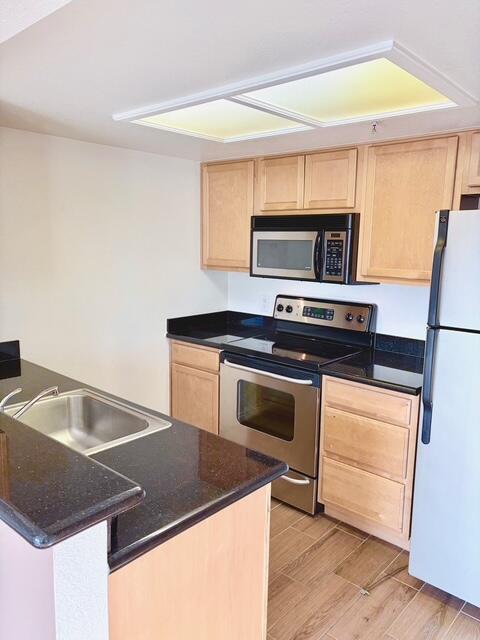 43376 Cook Street, Unit 88 Palm Desert, CA 92211 - Photo 13 of 38 a kitchen with kitchen island a stove a sink and a microwave