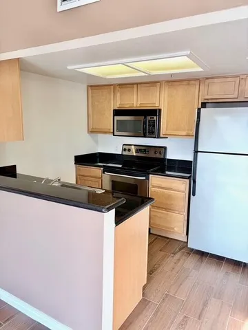 a kitchen with kitchen island a stove a sink and a microwave
