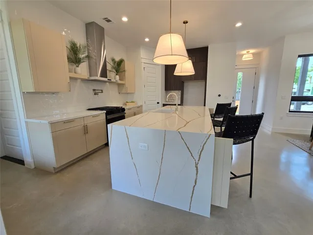 a kitchen with stainless steel appliances kitchen island a refrigerator and a sink