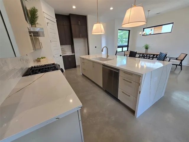 a large white kitchen with a sink a refrigerator and a stove