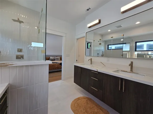 a large bathroom with a double vanity sink a mirror and a shower
