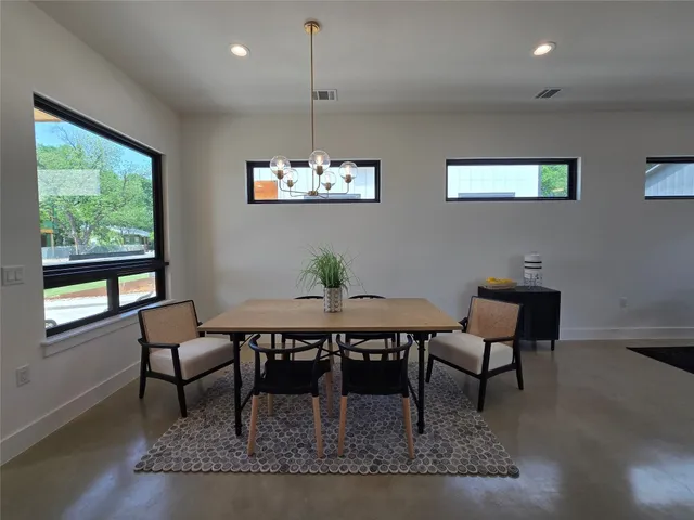a view of a dining room with furniture a chandelier and wooden floor