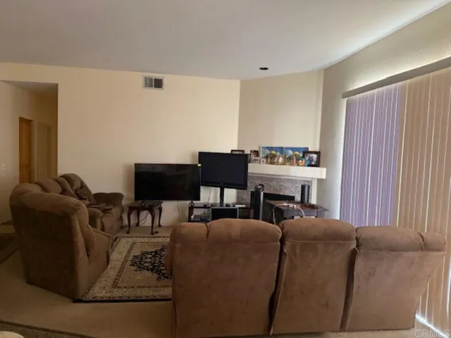 a living room with furniture a fireplace and kitchen view