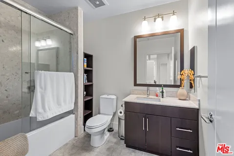 a bathroom with a double vanity sink toilet and shower