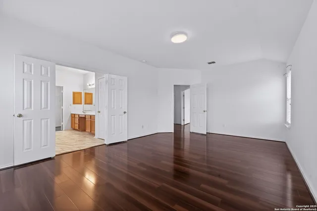 a view of an empty room with wooden floor