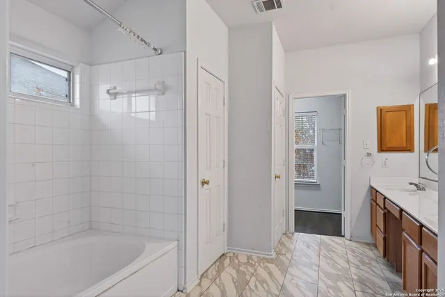 a bathroom with a bathtub sink and mirror