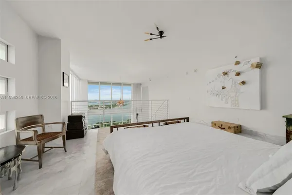 a bedroom with a bed a large window and walk in closet