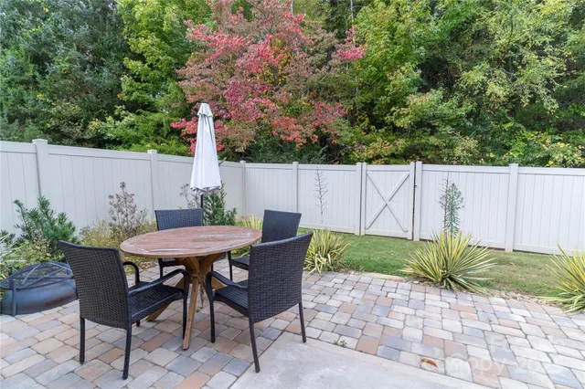 a view of a table and chairs in backyard of the house